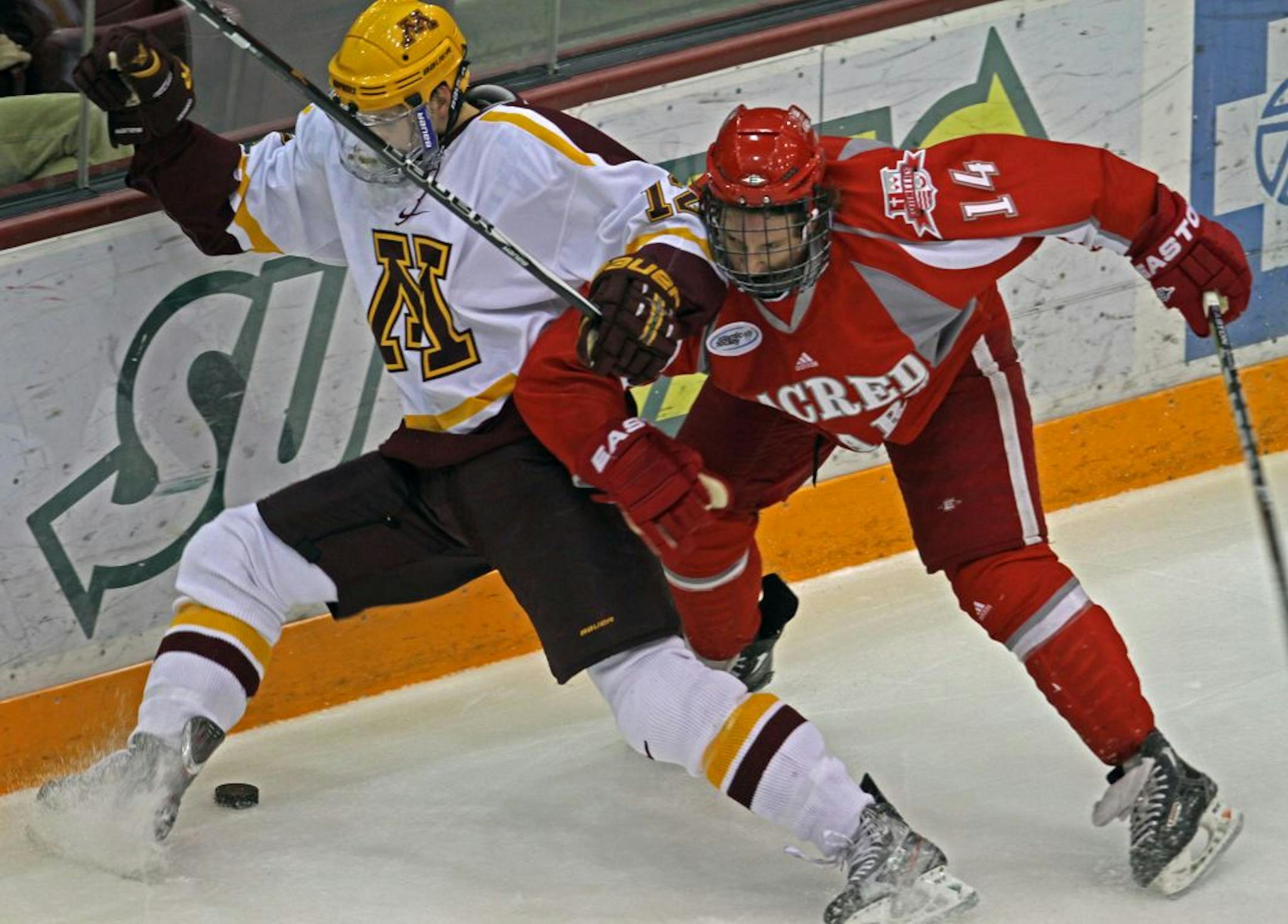 Gophers Justin Holl and Sacred Heart's Torin Snydeman battled for the puck in first period action at Mariucci Arena, 10/7/11.
