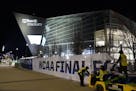 Workers take down NCAA Final Four signage outside U.S. Bank Stadium during last year's title game between Virginia and Texas Tech.