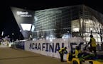Workers take down NCAA Final Four signage outside U.S. Bank Stadium during last year's title game between Virginia and Texas Tech.