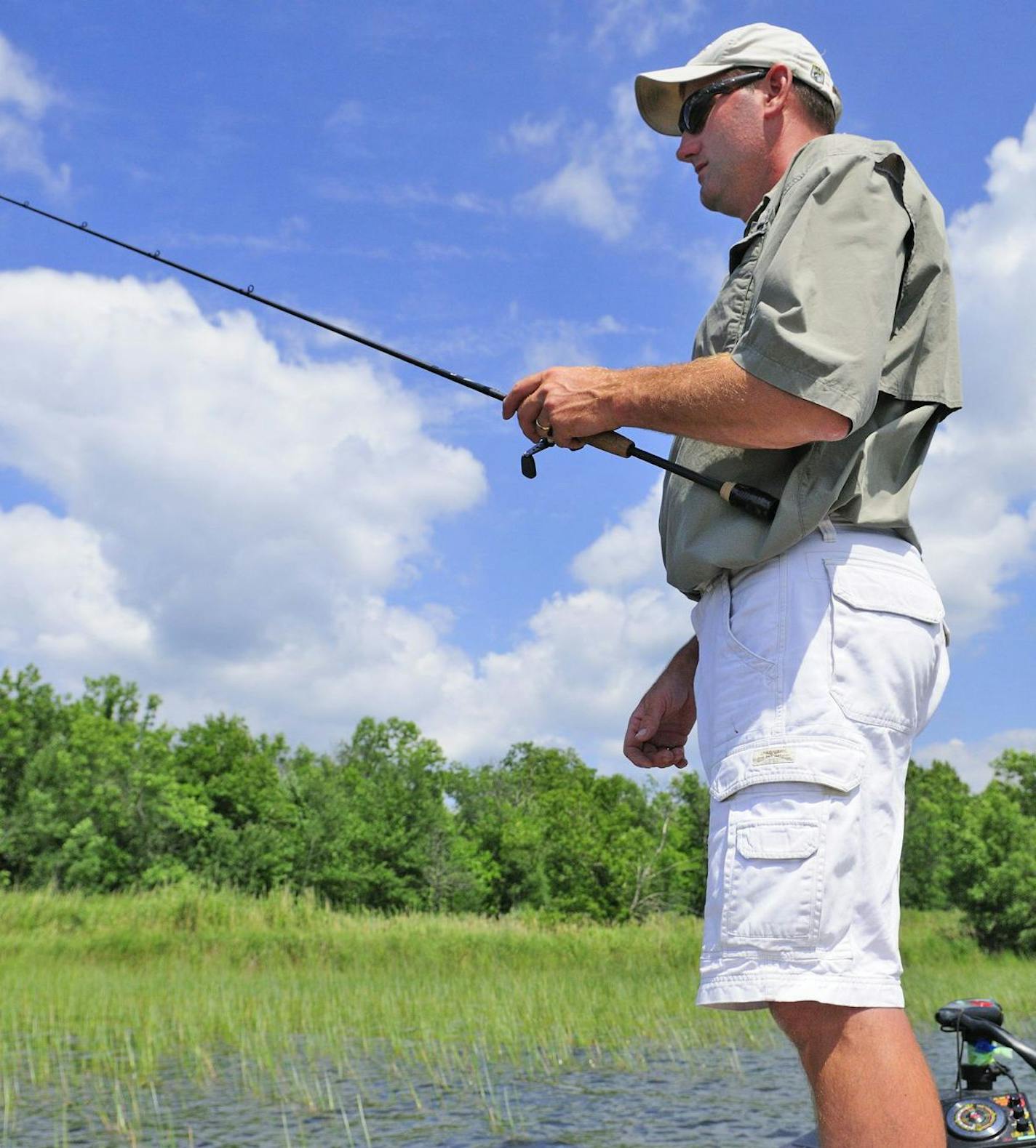 Lindy Frasl, a part-time bass tournament angler from Brainerd, jigs for bass in a bed of bulrushes.