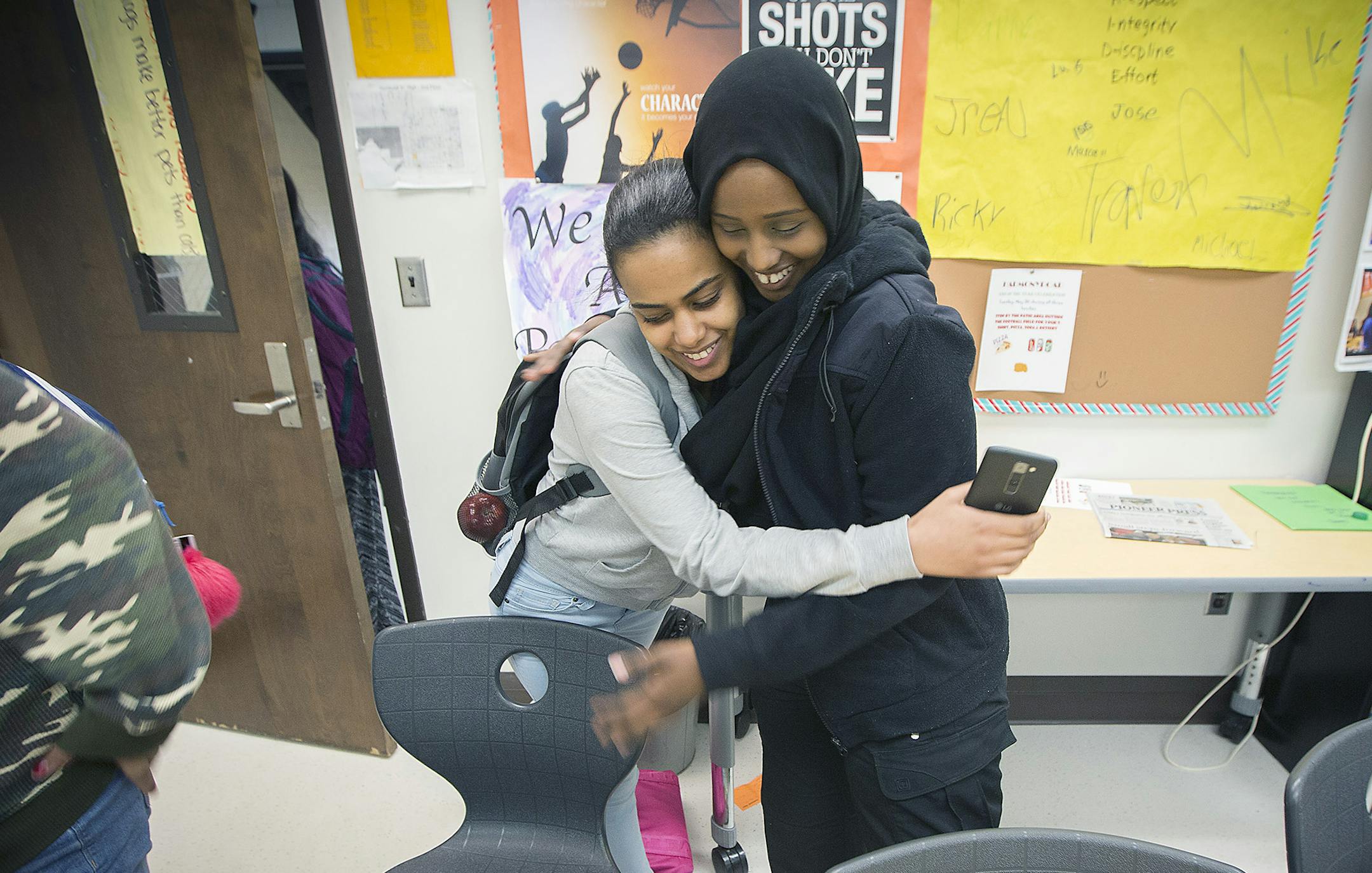 Kadra Mohamed, right, received a hug from a Humboldt High School student after she met with her and another group of teenage girls that she mentored throughout the school year. The girls find comfort and trust in St. Paul's first female Somali police officer. ] ELIZABETH FLORES ï liz.flores@startribune.com