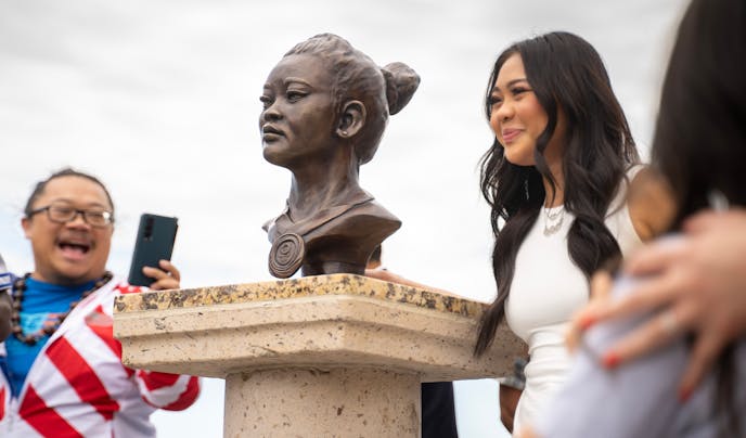 Olympic gymnast Suni Lee stood next to the newly-unveiled bronze bust of the, created by artist Seexeng Lee, at Phalen Regional Park in St. Paul, Minn. on "Sunisa Lee Day," Sunday. The gold medal-winning Olympic gymnast from St. Paul has been an inspiration for young girls and the Hmong community.