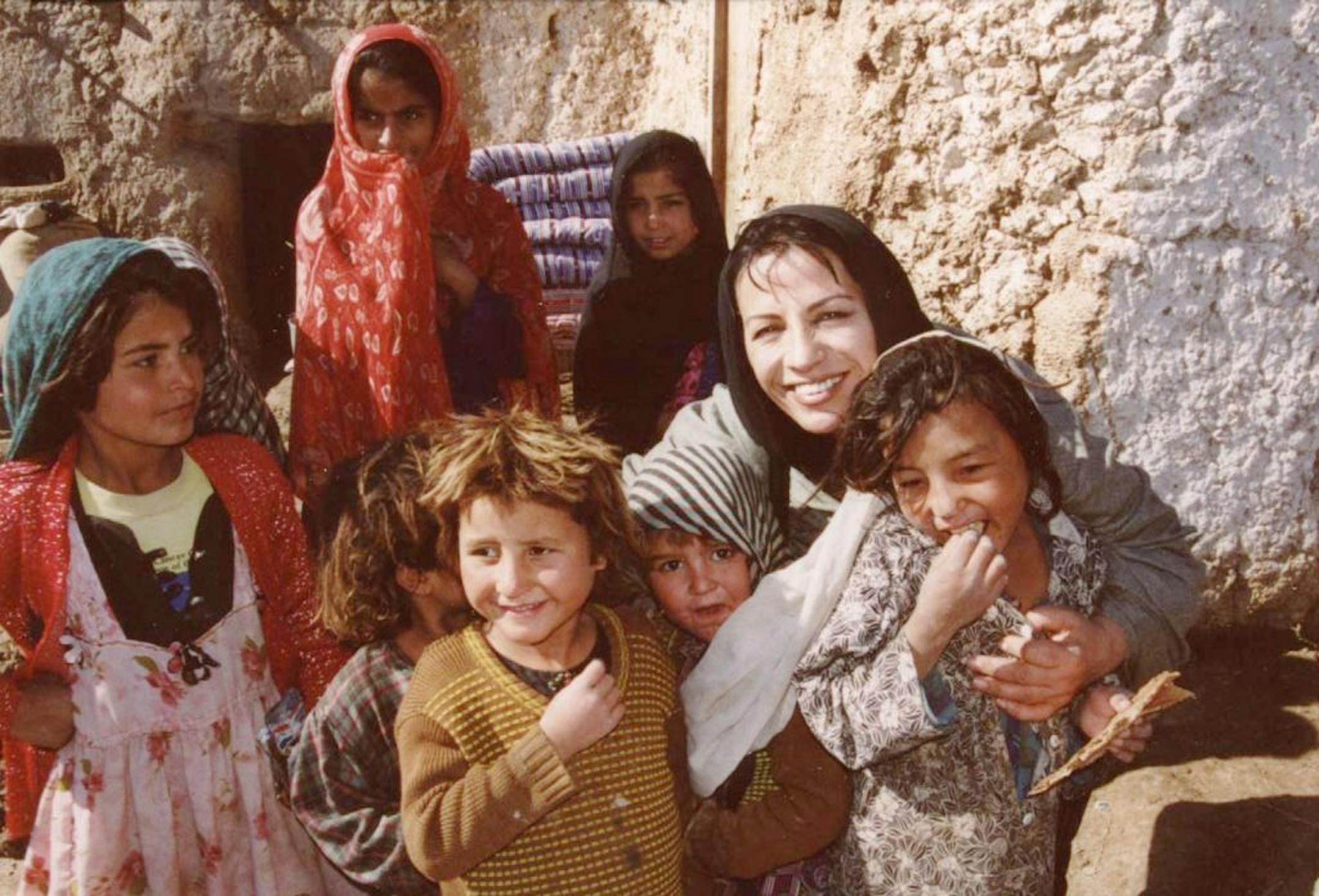 A few weeks after the September 11 attacks, Suraya posed with displaced children who had just received aid in the Takhar Province.