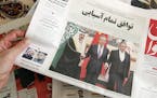 A man in Tehran holds a local newspaper reporting on its front page the China-brokered deal between Iran and Saudi Arabia to restore ties, signed in B