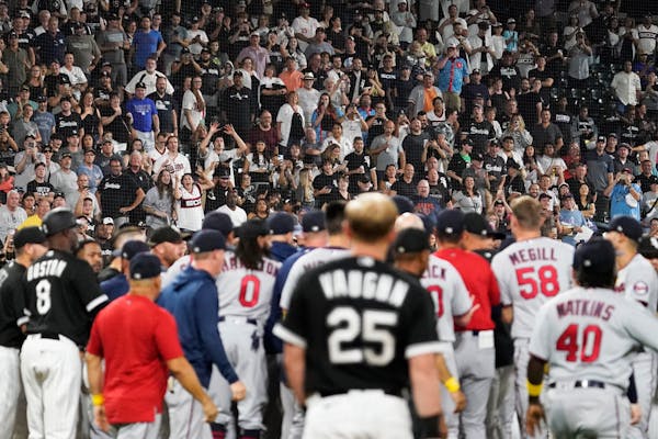 Fans stand as the benches clear after Chicago White Sox's Andrew Vaughn (25) was hit by pitch from Minnesota Twins reliever Jorge Lopez during the nin