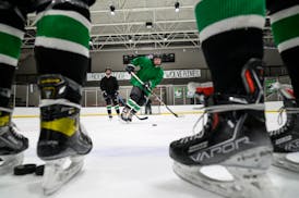 Rock Ridge's Grant Gerlach, center, of Virginia, passes away the puck during practice Tuesday, Feb. 22, 2022 at the Iron Trail Motors Event Center in 
