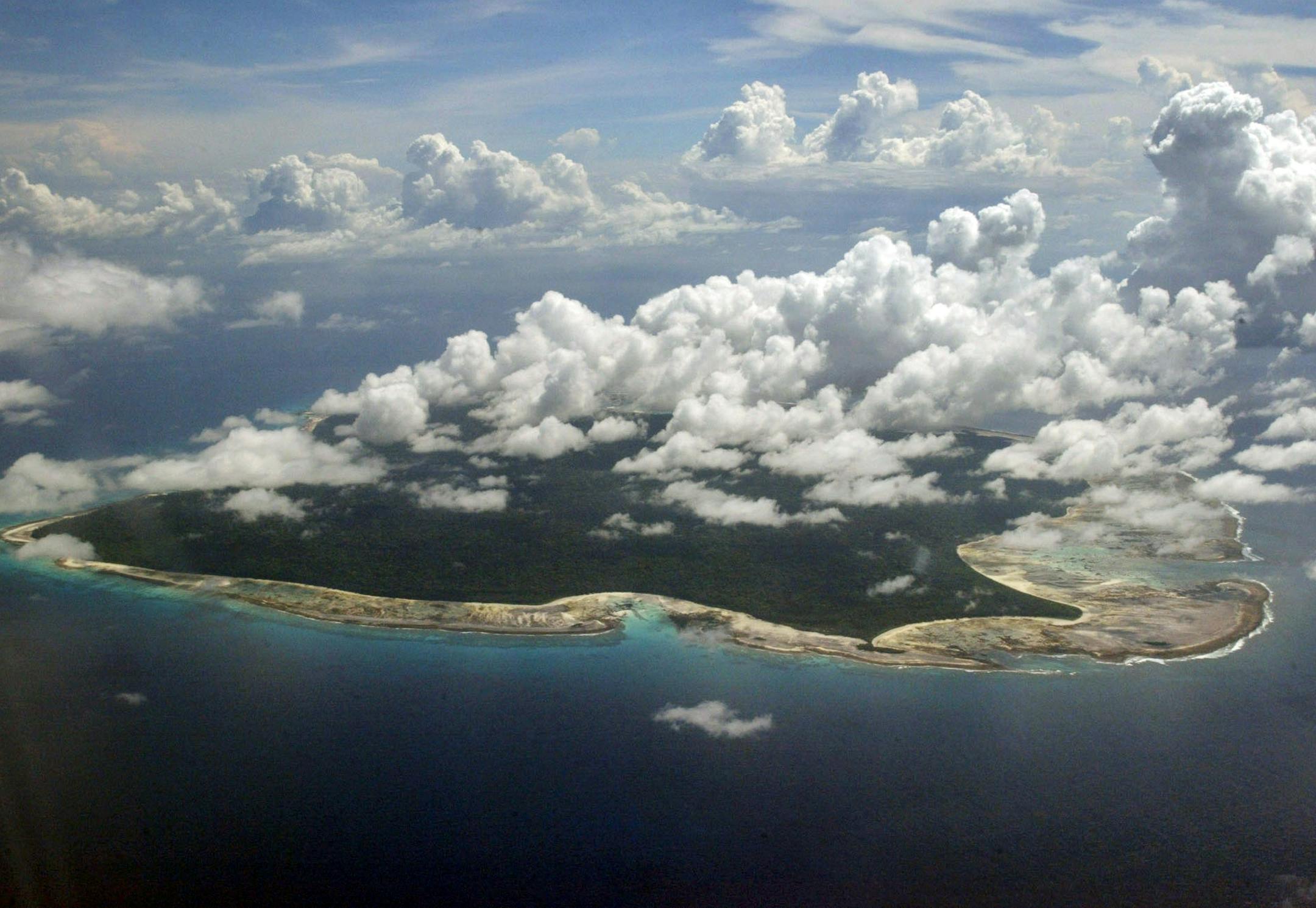 FILE – In this Nov. 14, 2005 file photo, clouds hang over the North Sentinel Island, in India's southeastern Andaman and Nicobar Islands. India used heat sensors on flights over hundreds of uninhabited Andaman Sea islands Friday, March 14, 2014, and will expand its search for the missing Malaysia Airlines jet farther west into the Bay of Bengal, officials said. The Indian-controlled archipelago that stretches south of Myanmar contains 572 islands covering an area of 720-by-52 kilometers.