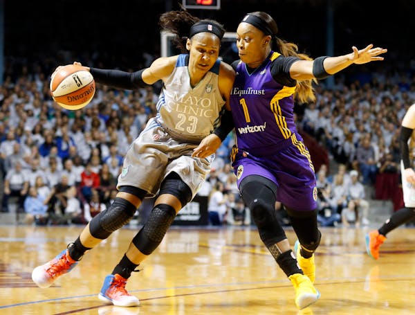 Minnesota Lynx's Maya Moore, left, drives around Los Angeles Sparks' Odyssey Sims during the first half of Game 5 of the WNBA Finals in Minneapolis la