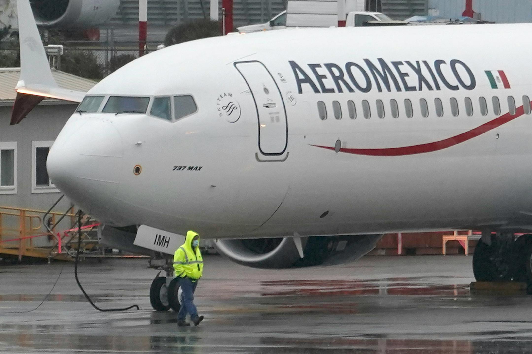 FILE - In this Nov. 18, 2020 file photo, a worker wearing a mask walks past a Boeing 737 Max 9 built for Aeromexico as it is prepared for a flight from Renton Municipal Airport, in Renton, Wash. U.S. regulators have downgraded Mexico's aviation safety rating, Tuesday, May 25, 2021, a move that prevents Mexican airlines from expanding flights to the United States just as travel is recovering from the pandemic. (AP Photo/Ted S. Warren, File)