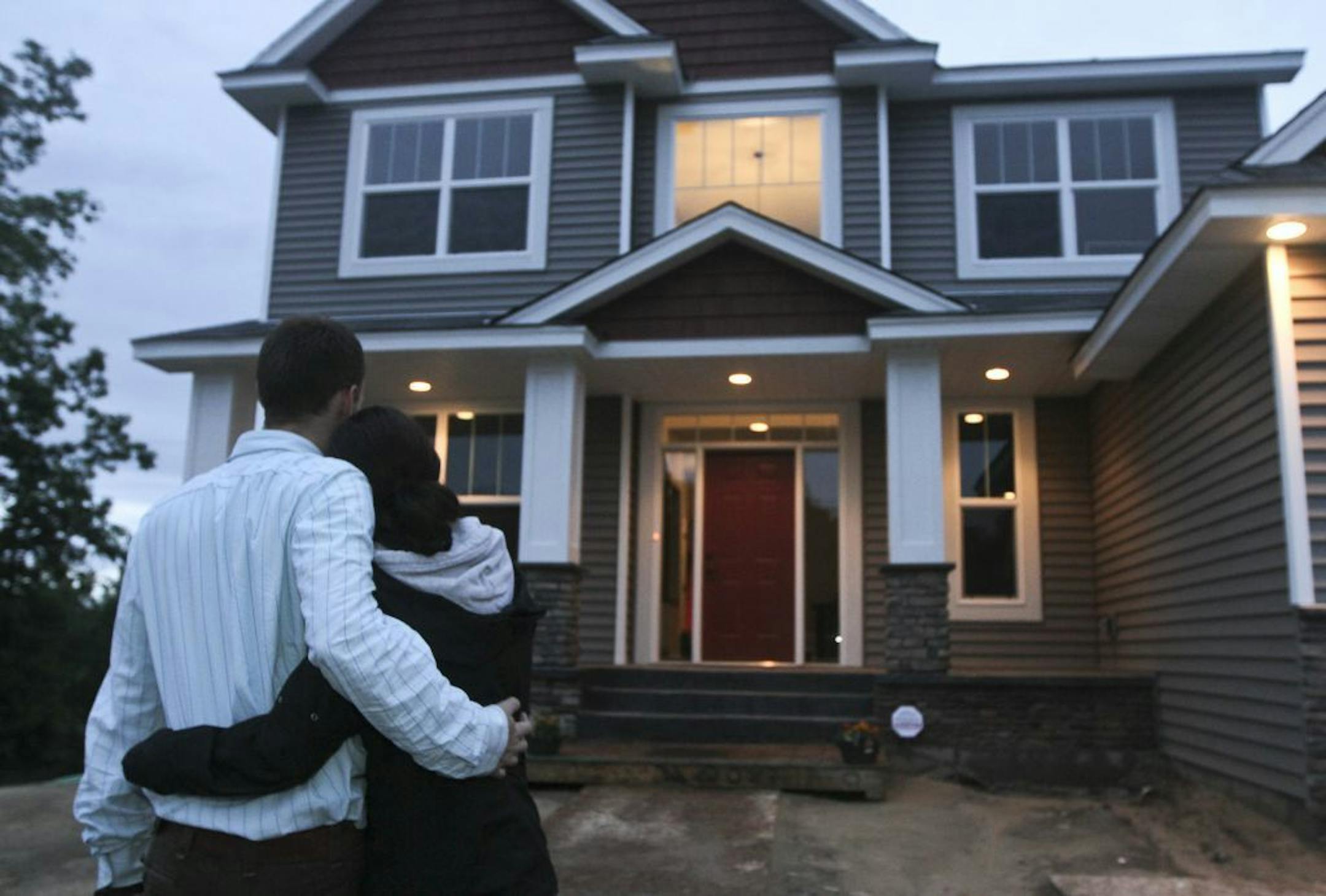 Not wanting their faces shown, Josh Stratton had his arm around his wife Sarah coming home after a meeting with detectives about some of their recovered items from a home invasion in Ham Lake Min., Thursday, May 24, 2012.
