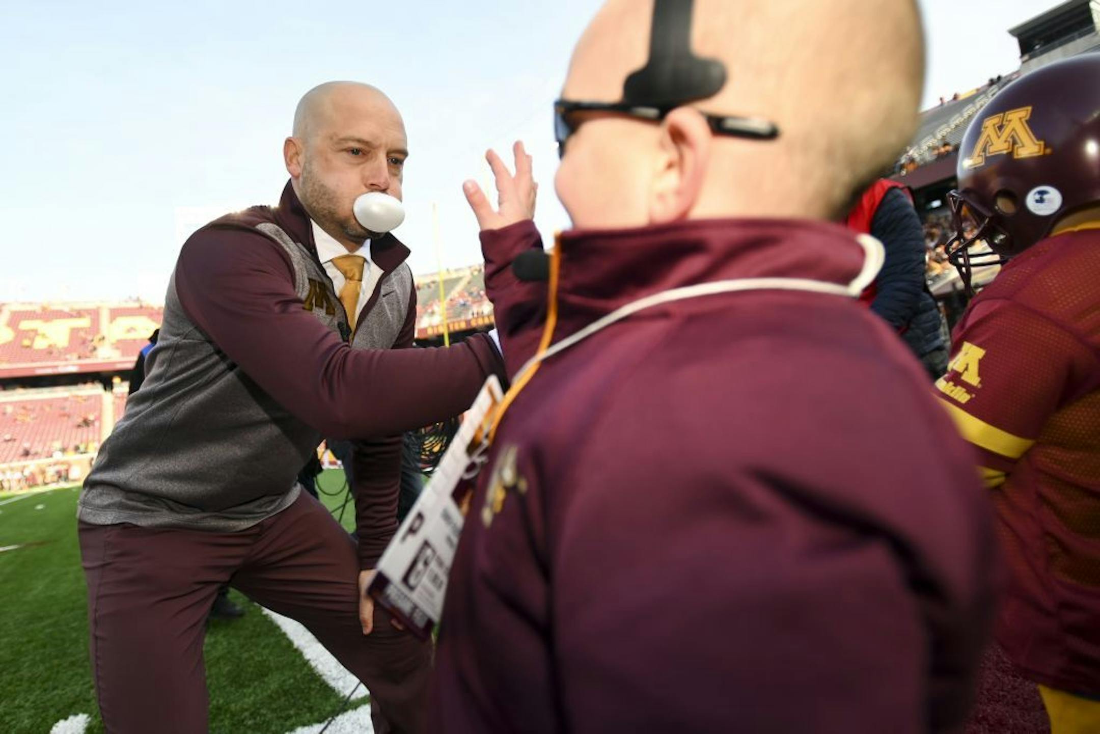 Minnesota Gophers head coach P.J. Fleck high fived young fan Scott McCauley, dressed as Fleck, and Scott's older brother Daniel, dressed as quarterback Tanner Morgan.