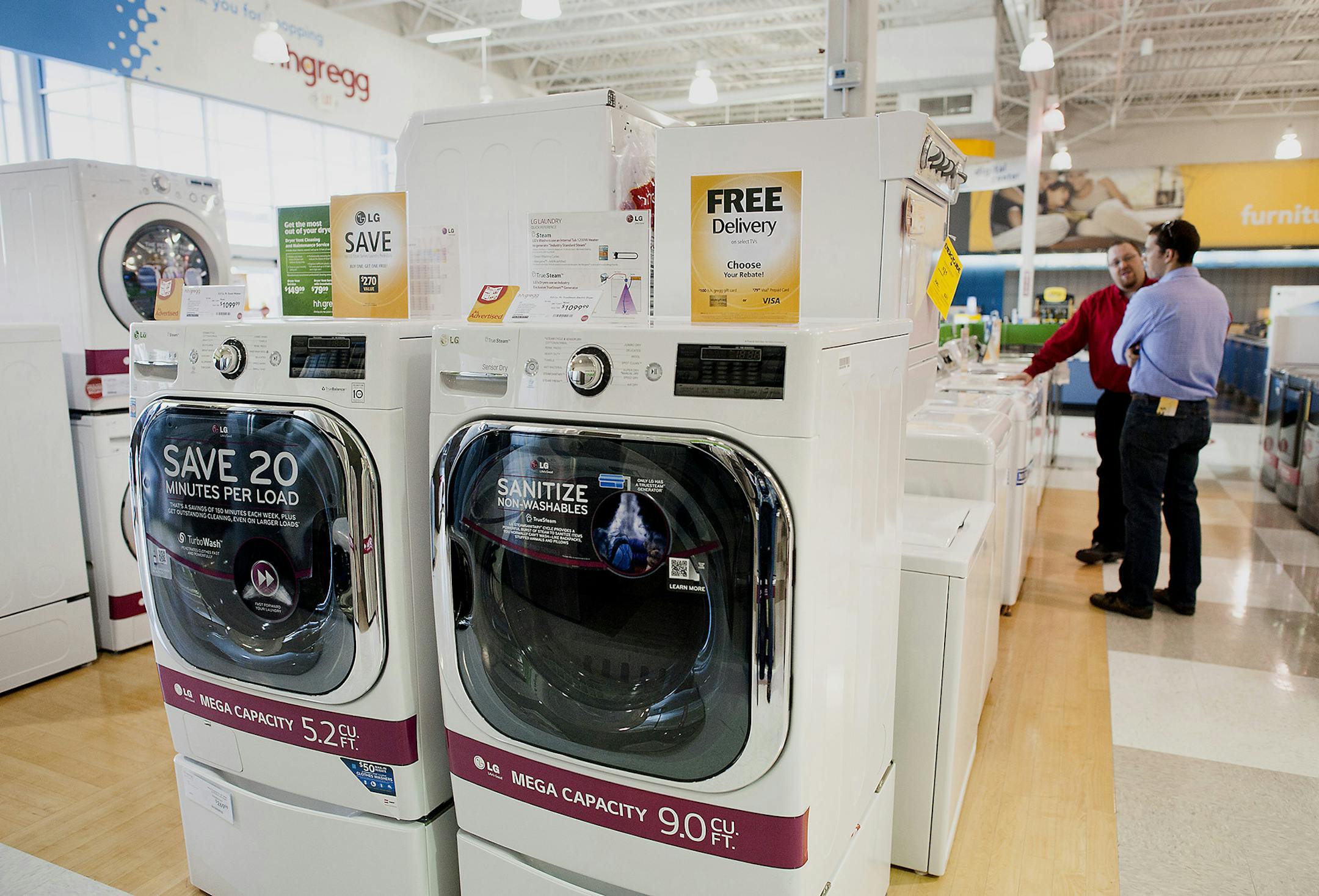 Washer and dryer sets are displayed for sale as an employee assists a customer at an H.H. Gregg Inc. store in Reynoldsburg, Ohio, U.S., on Sunday, May 18, 2014. The U.S. Census Bureau is scheduled to release durable goods figures on May 27. Photographer: Ty Wright/Bloomberg ORG XMIT: 493890759