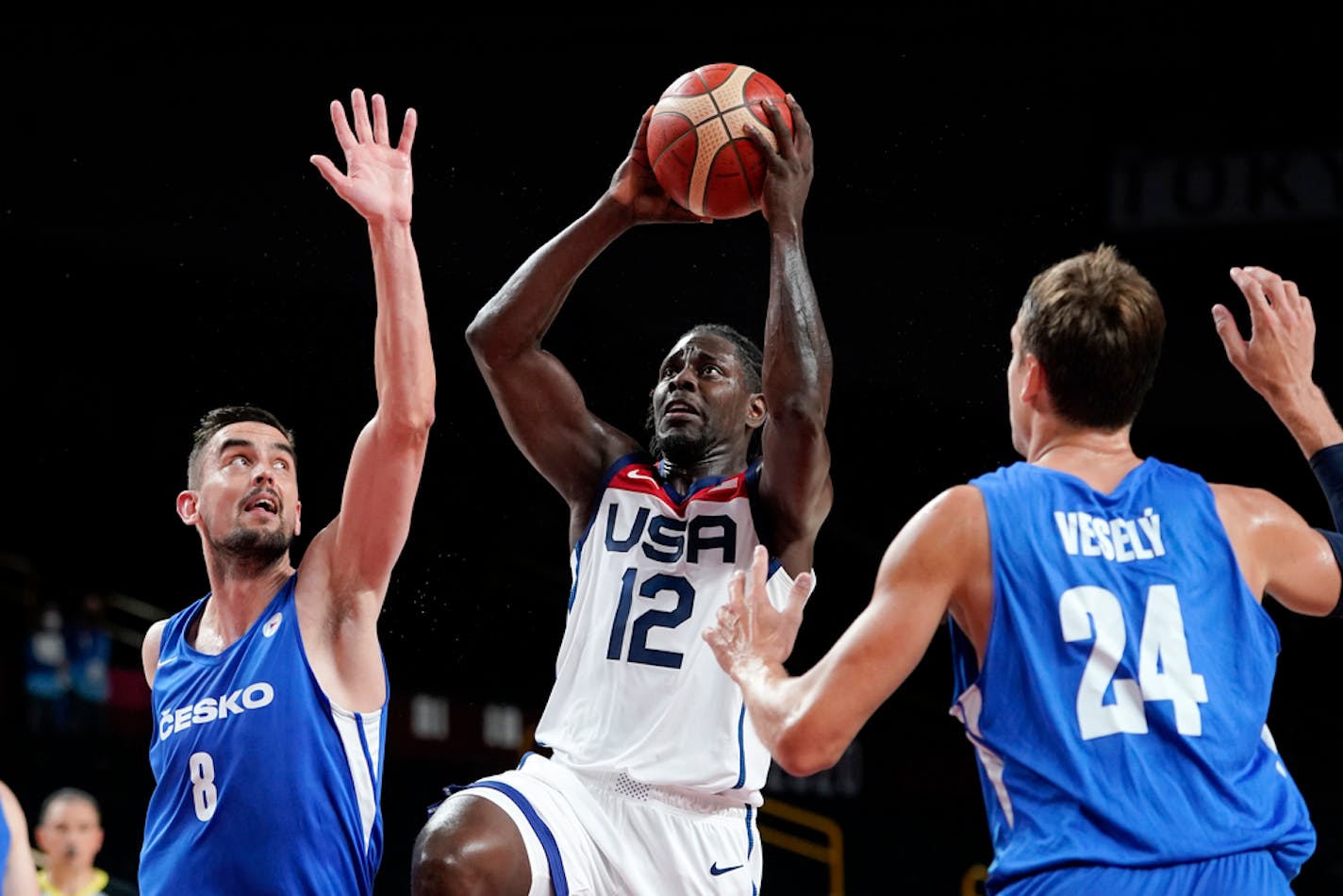 United States's Jrue Holiday (12) drives to the basket between the Czech Republic's Tomas Satoransky (8) and Jan Vesely (24) during a men's basketball preliminary round game at the 2020 Summer Olympics, Saturday, July 31, 2021, in Saitama, Japan. (AP Photo/Charlie Neibergall)