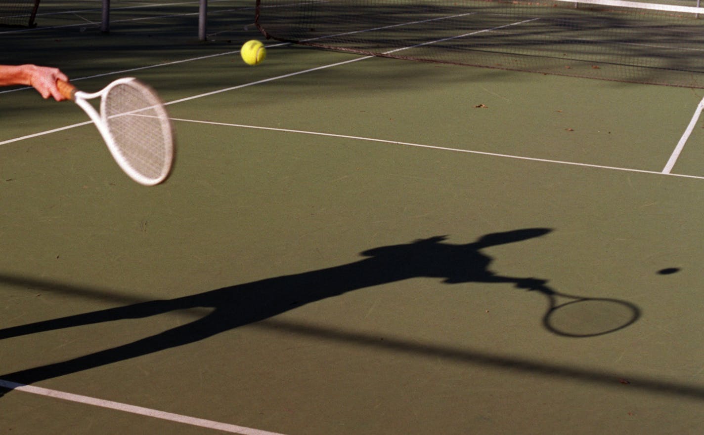 Lines Only-Tennis Ali Fry...Matt Tennant — Ali Fry, returns a ball to Matt Tennant both of Minneapolis during a friendly game of tennis at Kennwood park in Minneapolis on Wednesday afternoon. The two were making the most of the sunny weather which cast shadows on the players.