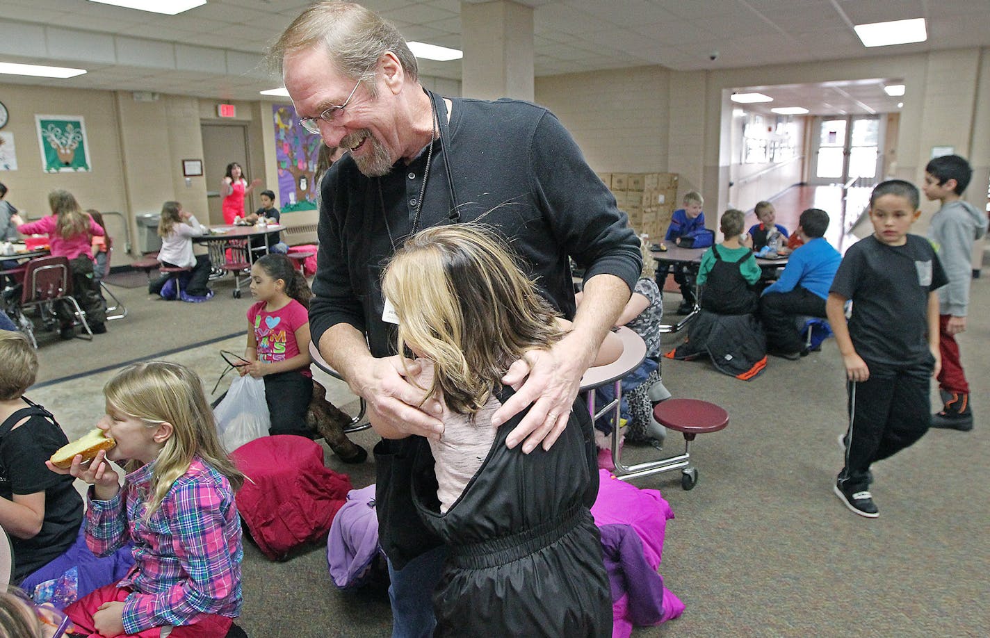 Former Teamster truck driver Ken Petersen was hugged by a student at Lincoln Center Elementary as he made his way through the cafeteria during the lunch hour this month in South St. Paul. His pension could be chopped in half under a new federal law.