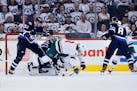 The Jets' Tyler Myers clears the Wild's Charlie Coyle from in front of goaltender Connor Hellebuyck during the second period in Game 5