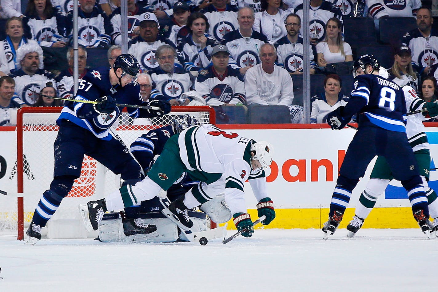 The Jets' Tyler Myers clears the Wild's Charlie Coyle from in front of goaltender Connor Hellebuyck during the second period in Game 5