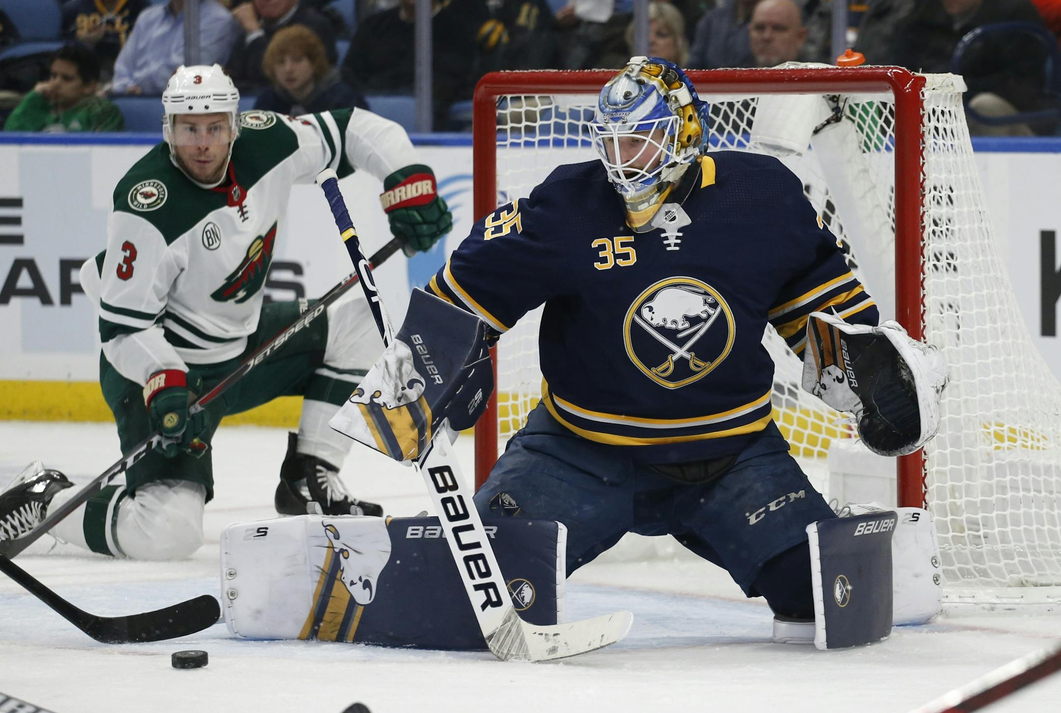 Buffalo Sabres goalie Linus Ullmark, right, stops a shot by Minnesota Wild forward Charlie Coyle, left, during the second period of an NHL hockey game, Tuesday, Feb. 5, 2019, in Buffalo N.Y.