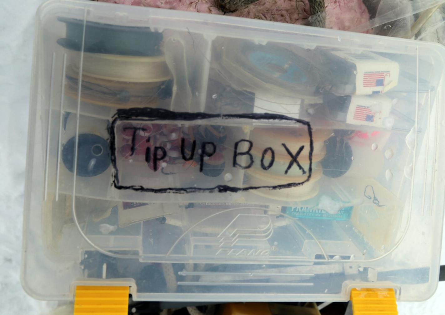 Staying organized while fishing is always a challenge. Here the small bobbers, sinkers and line used for tip-up fishing are stored in one compact sealable plastic box.