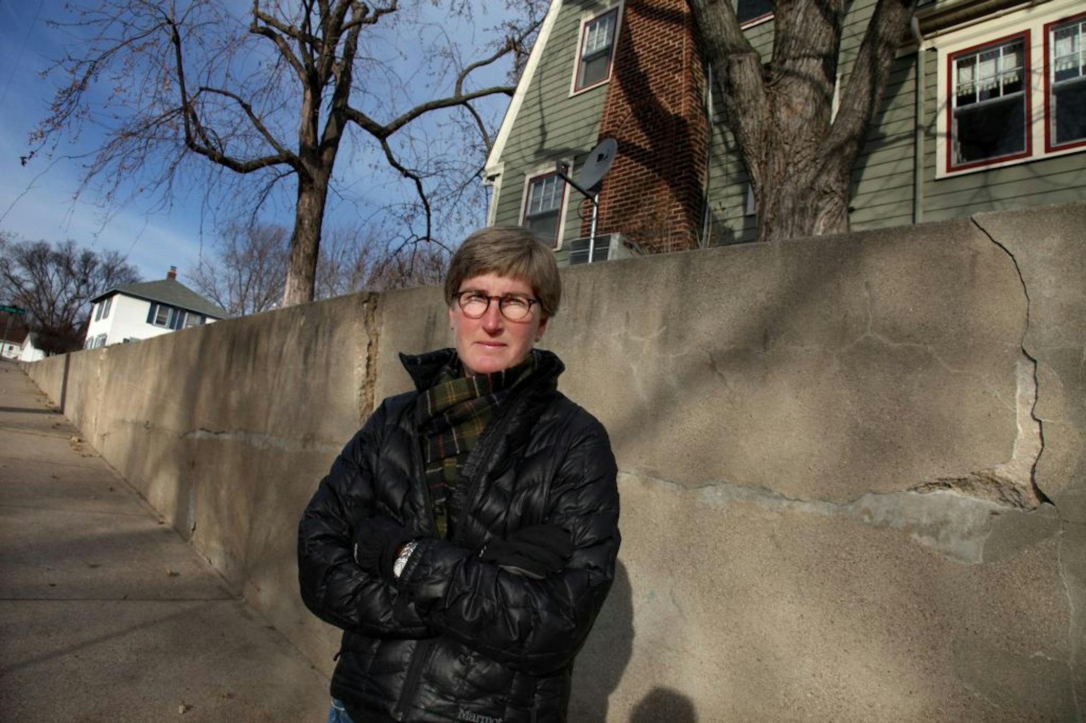 Elizabeth Howell stood near a cracked retaining wall near her home.
