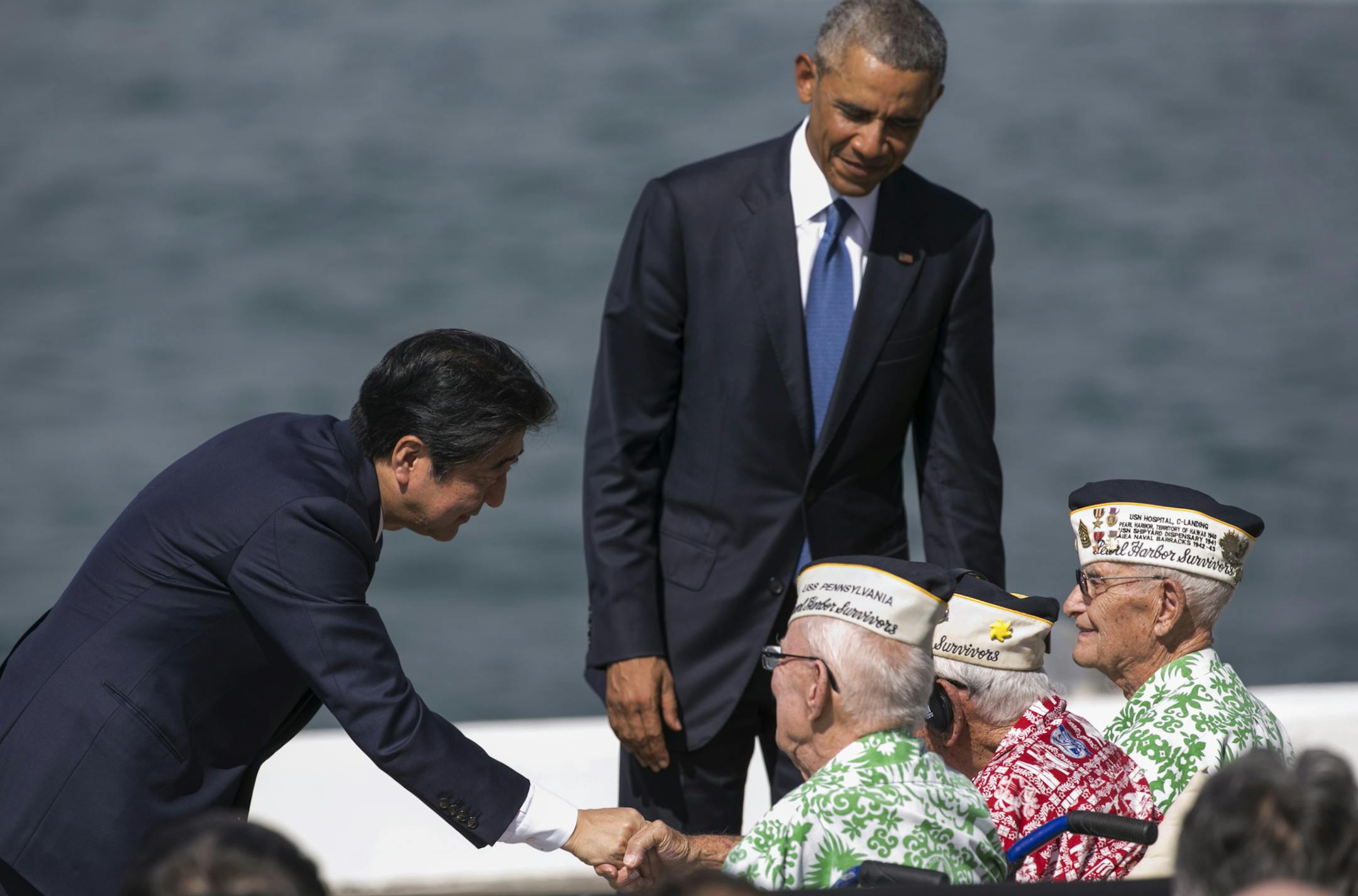 Japanese Prime Minister Shinzo Abe, left, and U.S. President Barack Obama speaks with Pearl Harbor veterans, all seated from left, Sterling Cale, Al Rodrigues and Everett Hyland at Joint Base Pearl Harbor Hickam, Tuesday, Dec. 27, 2016, in Honolulu. Abe and Obama made a historic pilgrimage Tuesday to the site where the devastating surprise attack sent America marching into World War II. (AP Photo/Marco Garcia) ORG XMIT: HIMG109