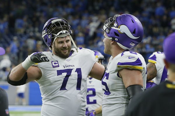 Minnesota Vikings offensive tackles Riley Reiff (71) celebrates the team's win with Brian O'Neill after the second half of an NFL football game agains