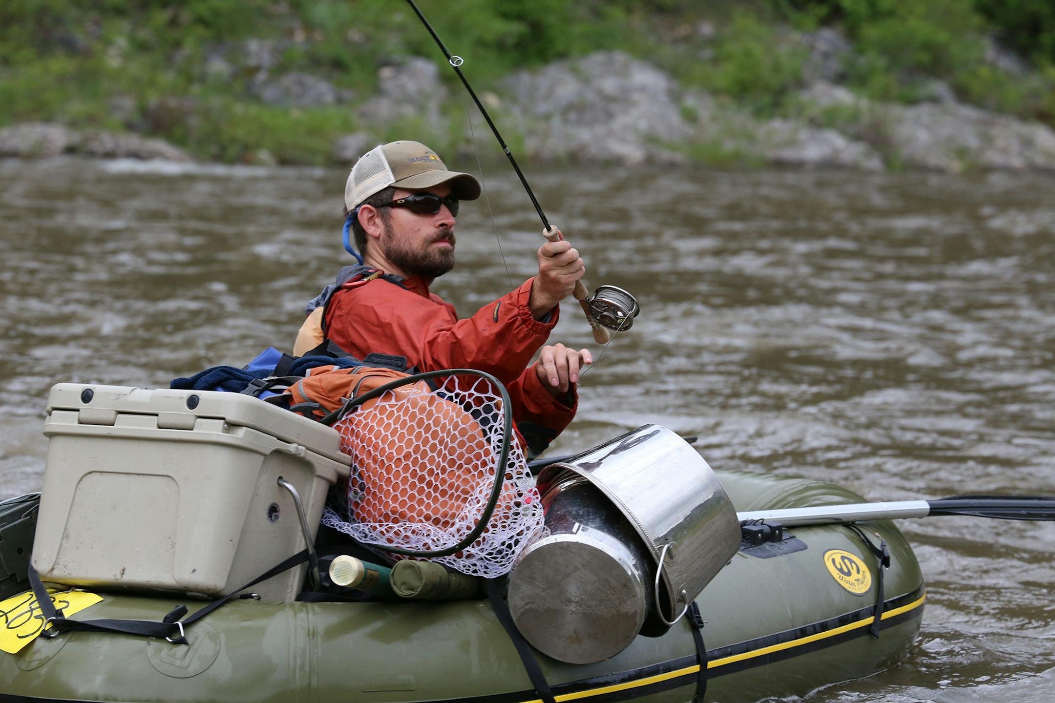 An angler in a one-man raft casts to a likely looking trout haunt while floating Montana's Smith River.
