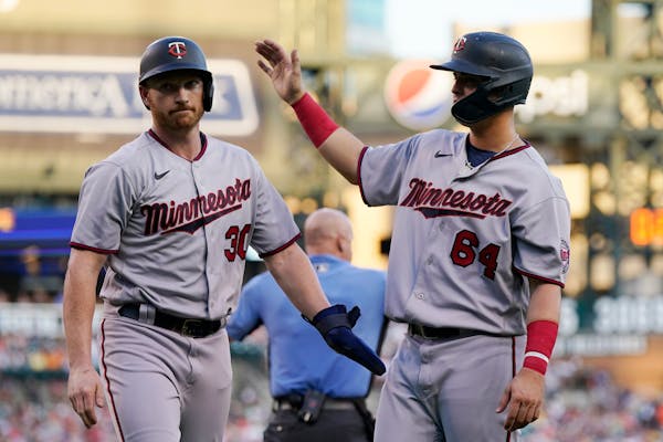 Kyle Garlick (30) is greeted by designated hitter Jose Miranda (64) after they both scored on a single by Luis Arraez during the seventh inning.