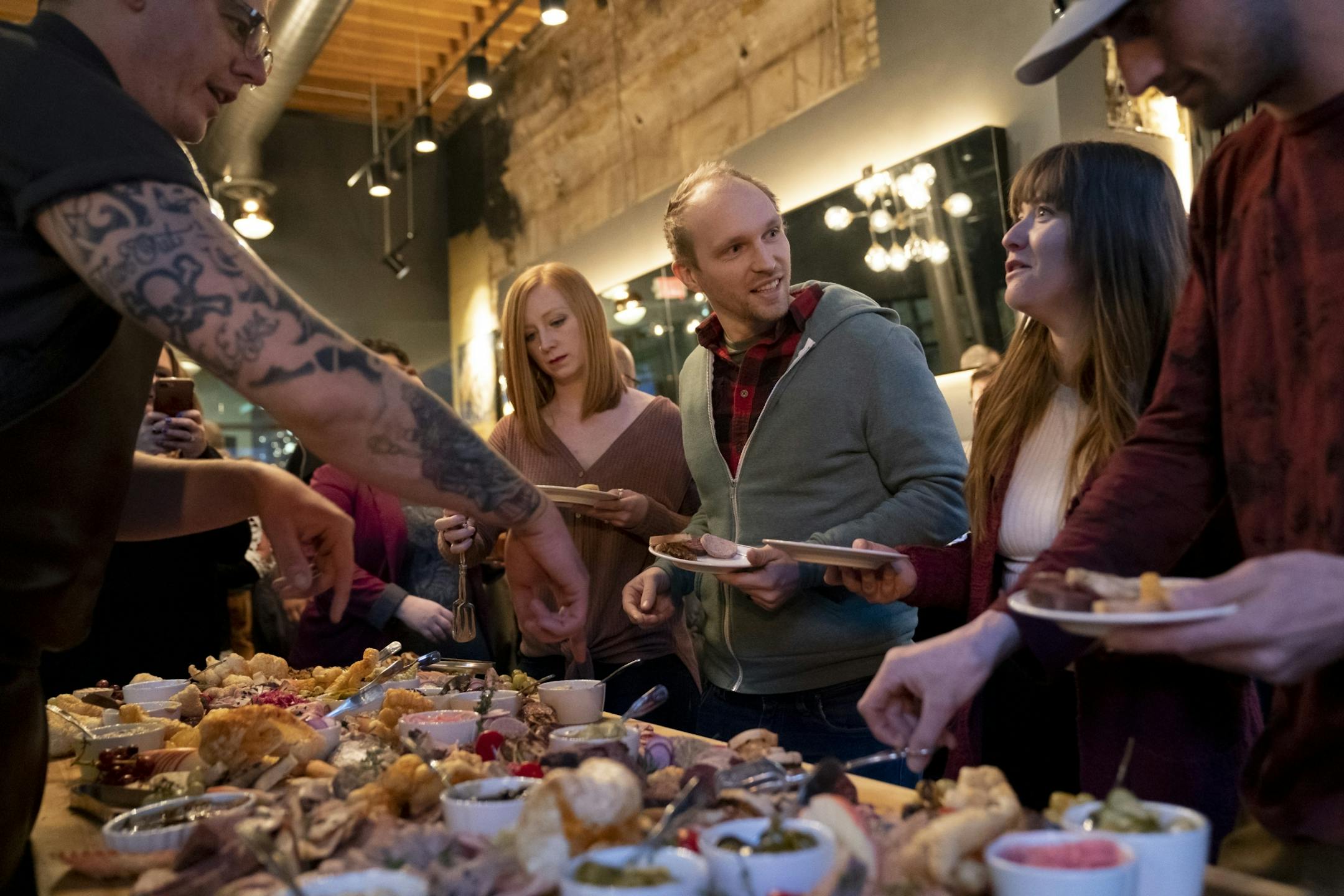 Top Chef contestant and chef Brian Young, left, explained all the meats on a smorgasbord during a six course meal at the Handsome Hog in St. Paul, Minn., on Thursday, January 17, 2019. Young was there to help chef and fellow contestant Justin Sutherland host the meal and a Top Chef viewing party. The guest from the left Courteney Perdue (CQ), Davis Perdue, Rachael Loney (CQ) and Reide Martin (CQ).