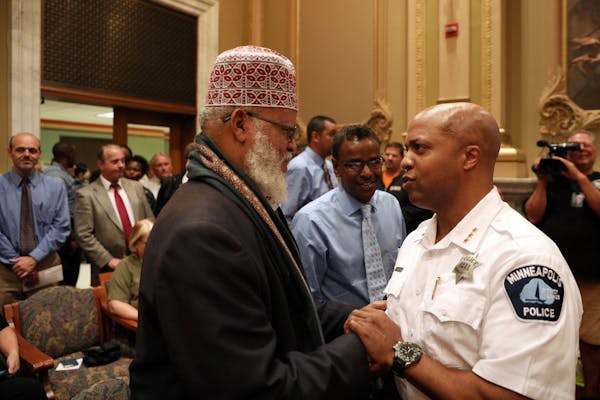 Acting police chief Medaria �Rondo� Arradondo shook hands with Imam Sheikh Sa'ad Musse Roble as Abdirizak Bihi looked on prior to the public heari