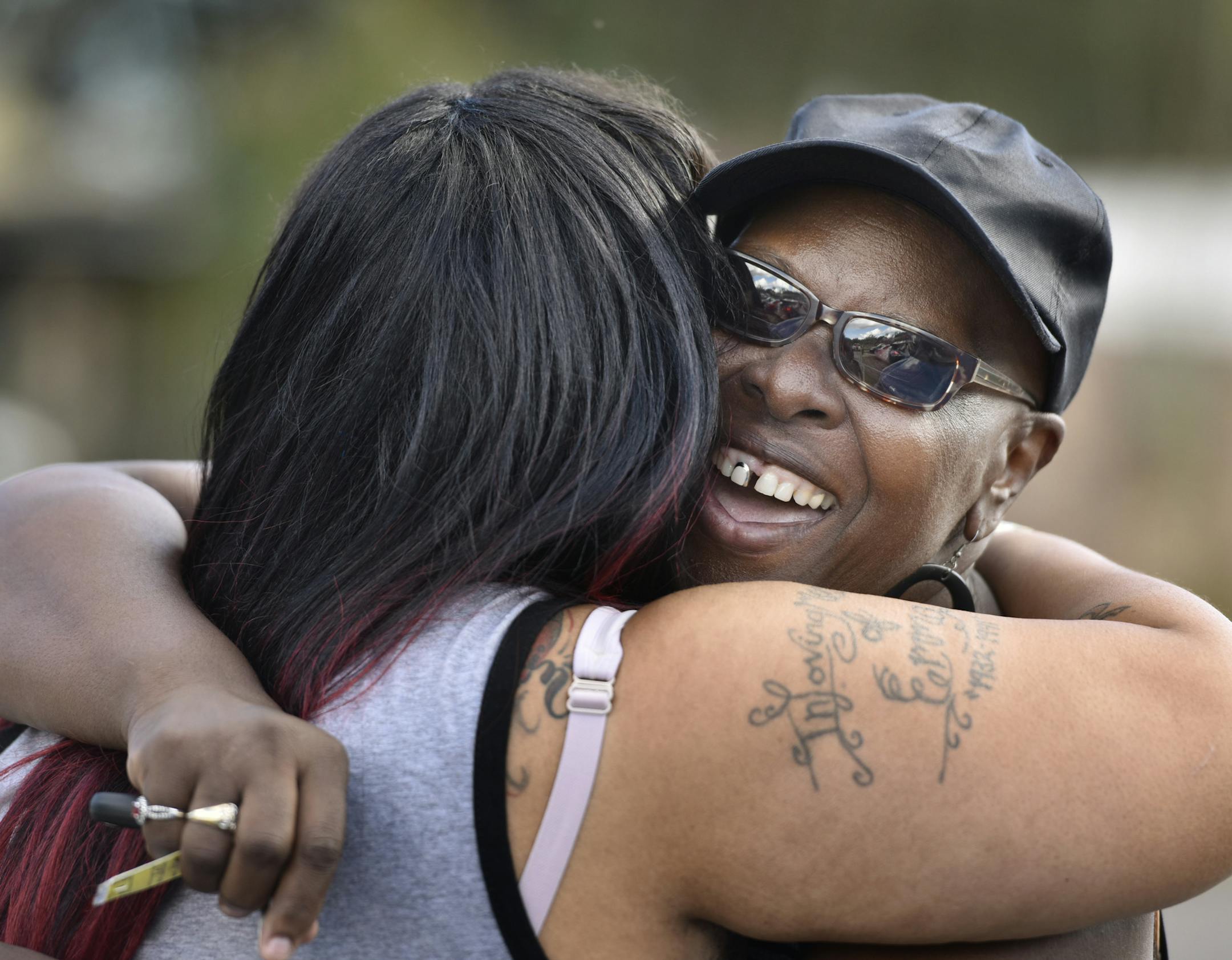 Velma Aiken, the paternal grandmother of Kamiyah Mobley, who was kidnapped as an infant 18 years ago, gets a congratulatory hug from a family member after Mobley was found safe Friday, Jan. 13, 2017, in Jacksonville, Fla. (Will Dickey /The Florida Times-Union via AP)