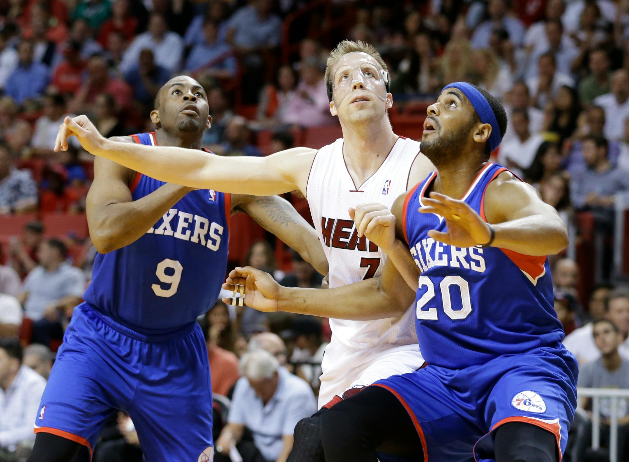 Philadelphia 76ers guard James Anderson (9) and forward Brandon Davies (20) battle for position with Miami Heat center Justin Hamilton during a free throw attempt during the first half of an NBA basketball game, Wednesday, April 16, 2014 in Miami. (AP Photo/Wilfredo Lee)