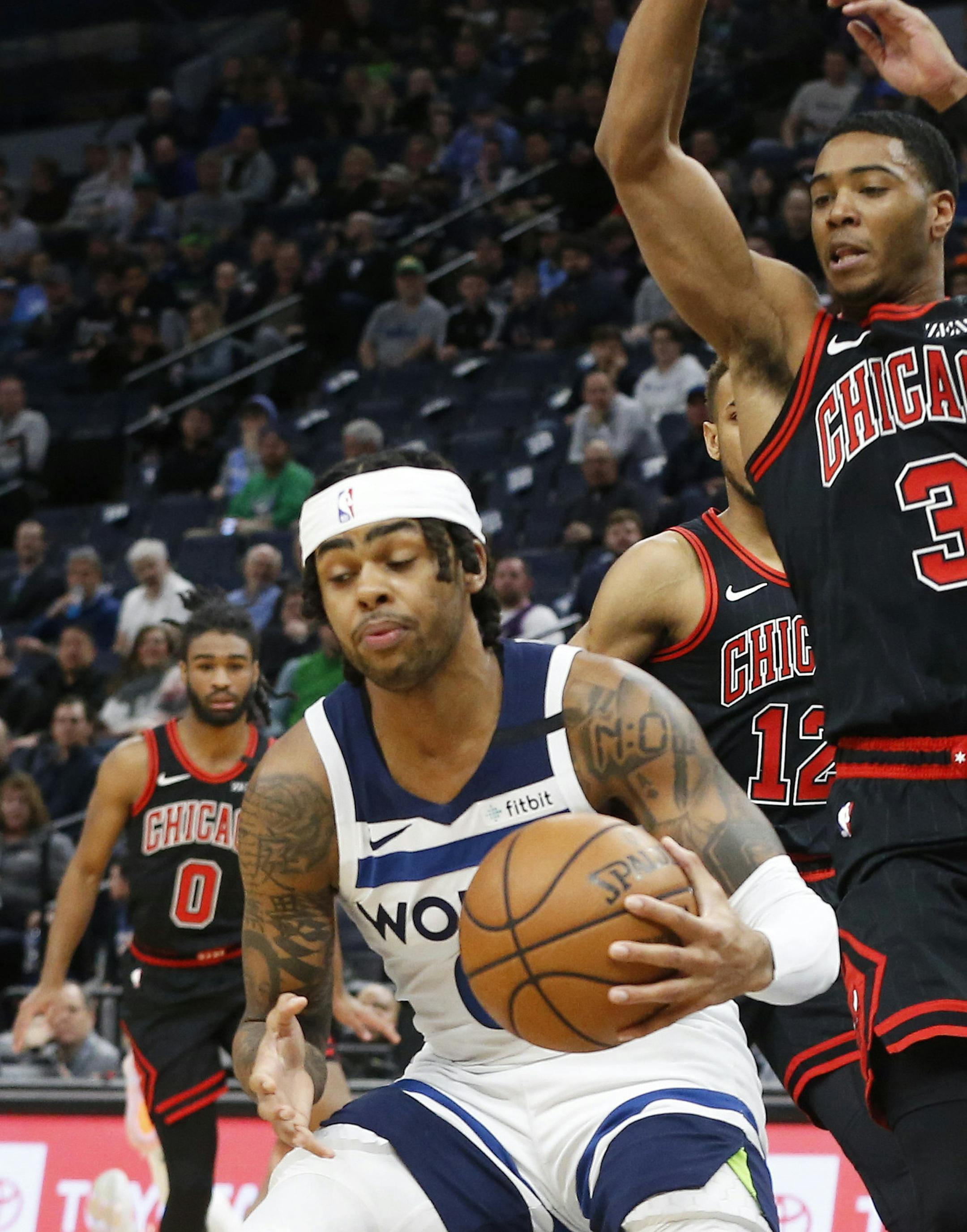 Minnesota Timberwolves' D'Angelo Russell, left, evades the defensive efforts of Chicago Bulls' Shaquille Harrison in the first half of an NBA basketball game Wednesday, March 4, 2020 in Minneapolis. (AP Photo/Jim Mone)