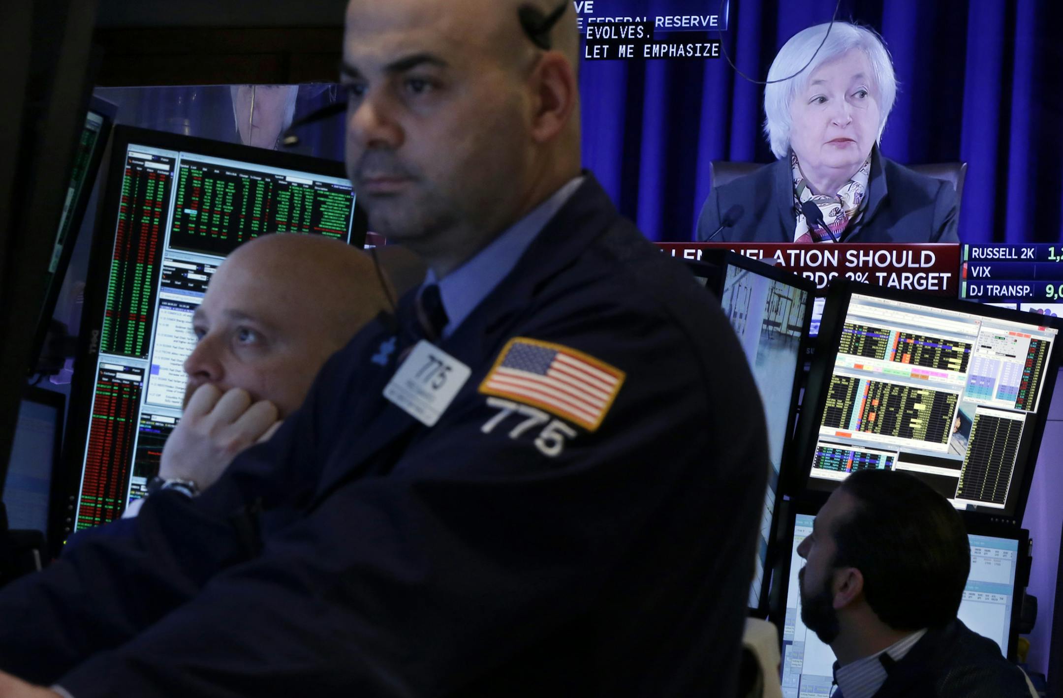 Traders work in a booth on the floor of the New York Stock Exchange, as Federal Reserve Chair Janet Yellen's news conference appears on a screen, Wednesday, March 18, 2015. The Federal Reserve is signaling that it's edging closer to raising interest rates from record lows in light of a strengthening job market. The Fed no longer says it will be "patient" in starting to raise its benchmark rate. (AP Photo/Richard Drew)