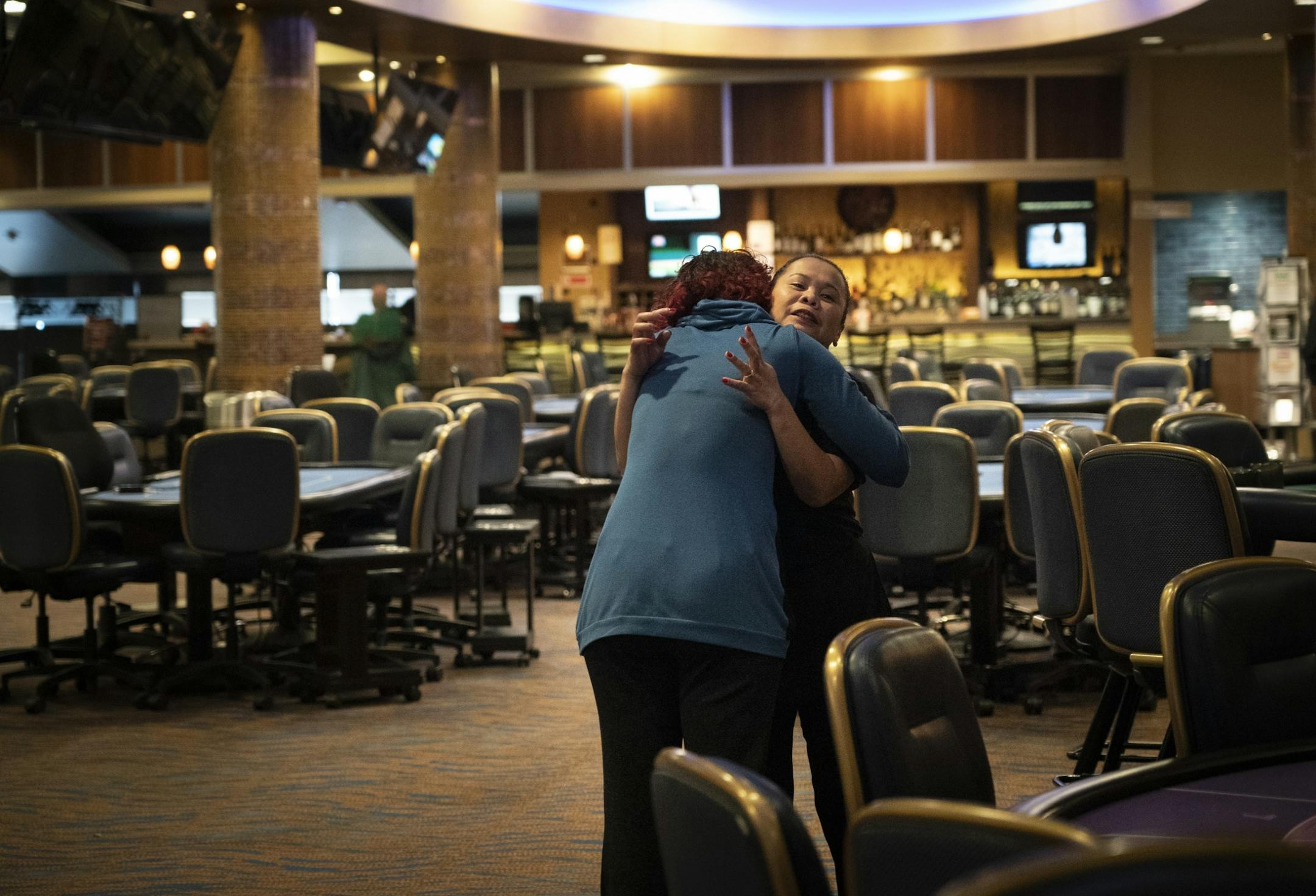 Server Julie Hvidsten hugged casino executive host Azure Alder (in blue) to say goodbye as they prepared to close Canterbury Park in Shakopee, Minn., on Monday, March 16, 2020 in response to concerns about COVID-19. Canterbury Park is traditionally open 24/7 only closing annually for 12 hours over Christmas.