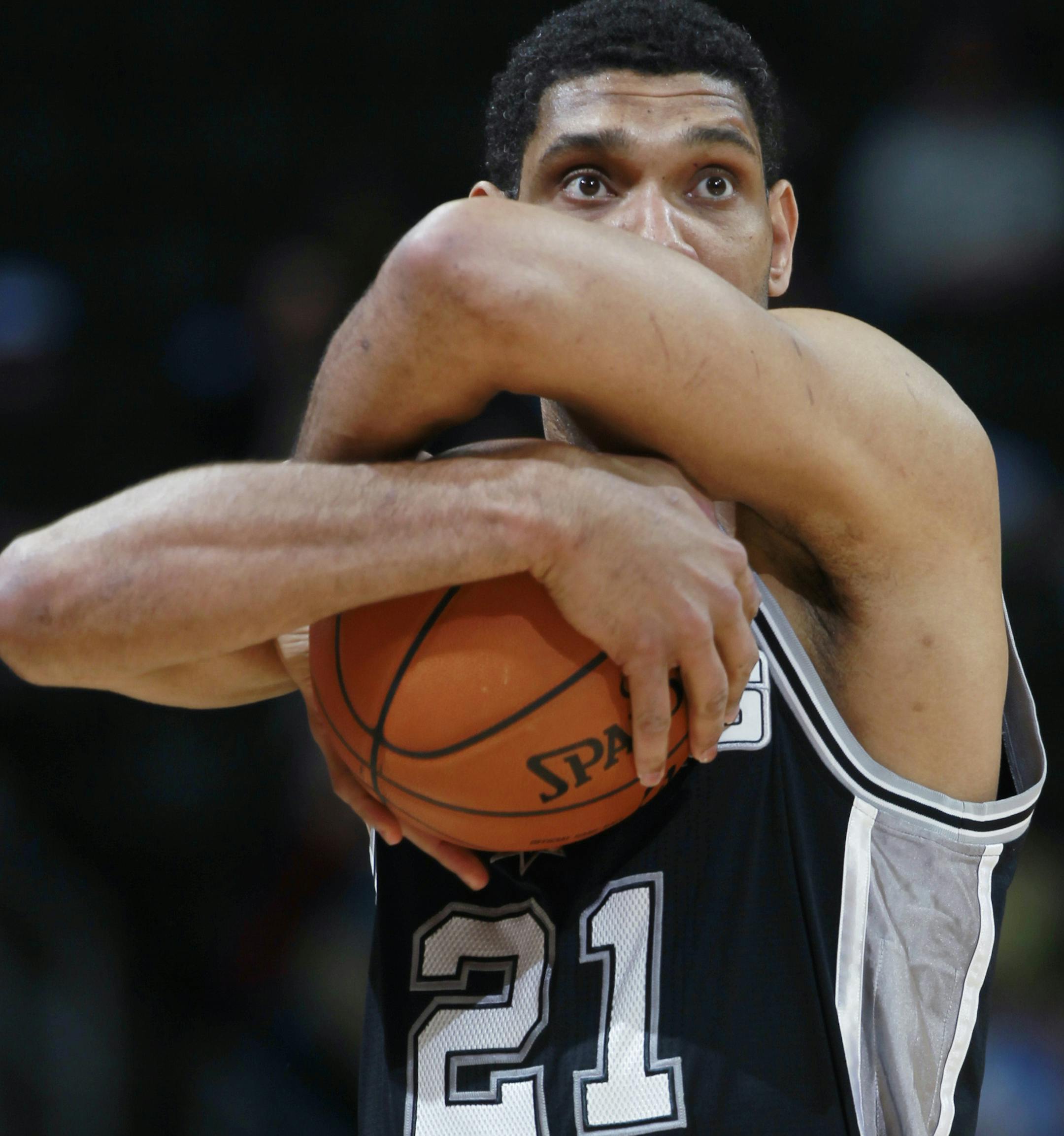 San Antonio Spurs center Tim Duncan embraces the game ball before tipping off against the Denver Nuggets in the first quarter of an NBA basketball game in Denver on Friday, March 28, 2014. (AP Photo/David Zalubowski) ORG XMIT: OTKDZ143