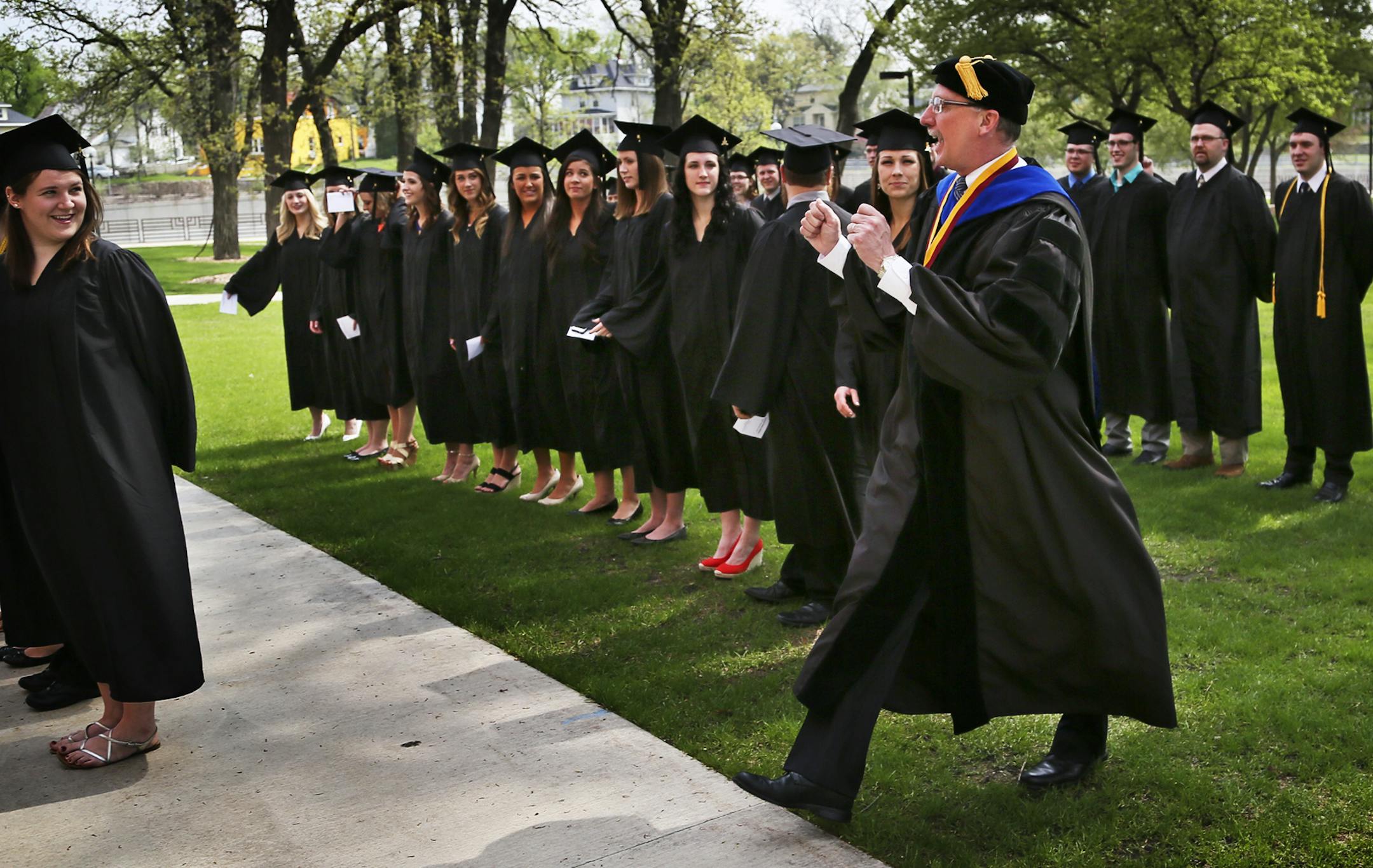 After posing for photos with graduates to be, University of Minnesota, Rochester chancellor Stephen Lehmkuhle walks to the front of the students to show them how to place their tassle prior to the graduation ceremonty at Mayo Civic Center Saturday, May 18, 2013 in Rochester, MN.](DAVID JOLES/STARTRIBUNE) djoles@startribune The first-ever class of undergrads at the University of Minnesota, Rochester graduate this weekend. When they began as freshmen, there were no dorms, no upperclassmen, no masc