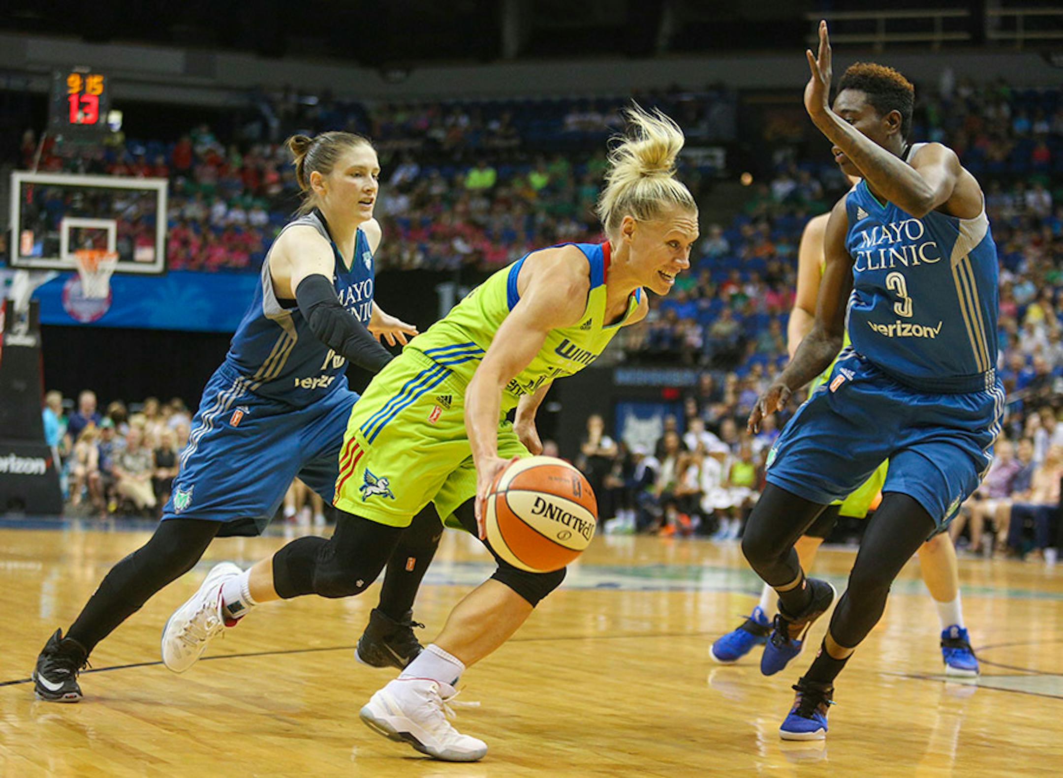 Dallas Wings guard Erin Phillips (31) drives past Minnesota Lynx guard Lindsay Whalen (13) and forward Natasha Howard (3).