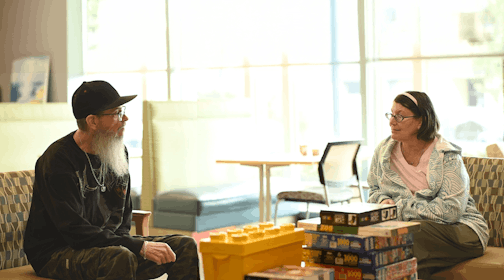 George and Barbara chat in a Rising Cedar Apartments common area
