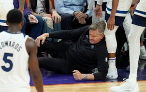Wolves coach Chris Finch holds his knee after colliding with guard Mike Conley late in Sunday's game at Phoenix. Finch had to be helped off the floor 