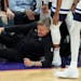 Wolves coach Chris Finch holds his knee after colliding with guard Mike Conley late in Sunday's game at Phoenix. Finch had to be helped off the floor 