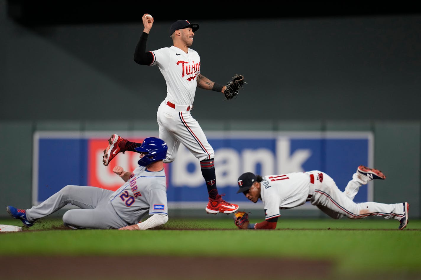 Minnesota Twins shortstop Carlos Correa throws to first base after forcing out New York Mets' Pete Alonso, left, during the ninth inning of a baseball game Friday, Sept. 8, 2023, in Minneapolis. Mark Vientos was safe at first. (AP Photo/Abbie Parr)