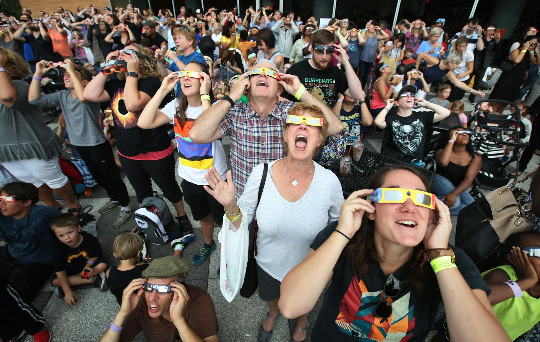 Carolyn Wharton left , John Whaley, Annette Whaley and Lauren Whaley join hundreds of other people to watch a partial eclipse at the Science Museum of Minnesota Monday August 21, 2017 in St. Paul, MN.