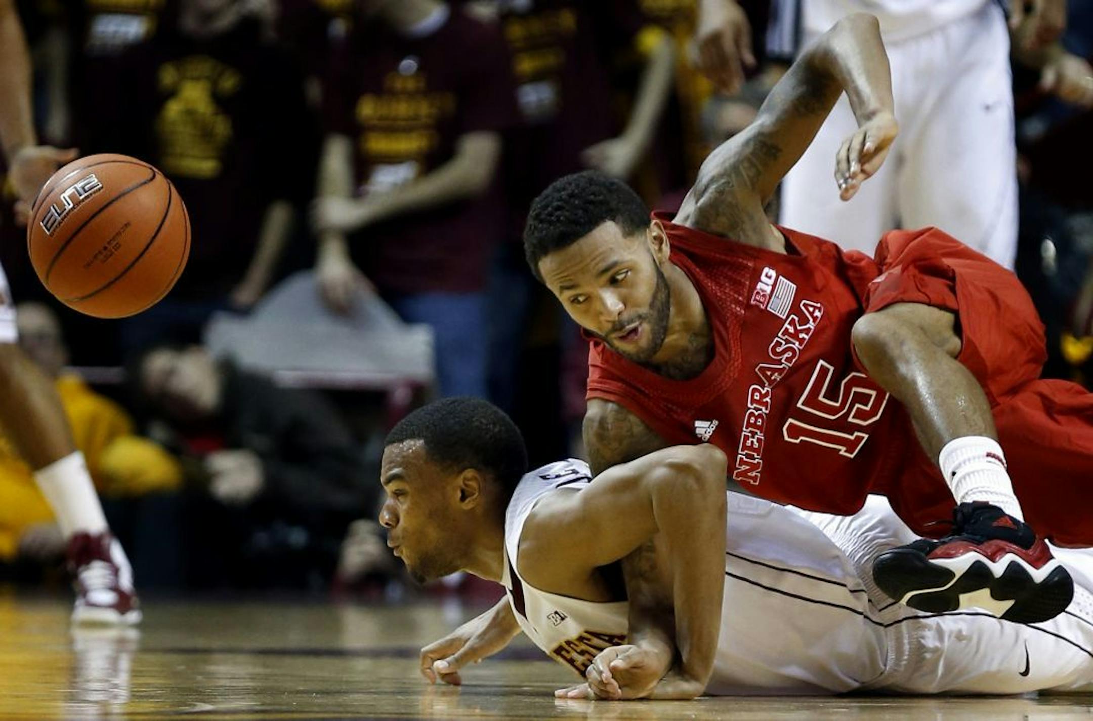 Andre Hollins (1) and Ray Gallegos (15) fought for a loose ball in the first half of the Gophers-Nebraska game.