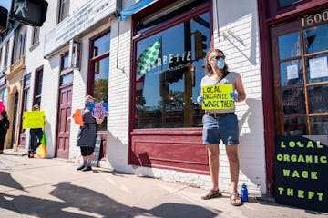 Nick Nootenboom, from right, who worked as a bartender at Tiny Diner, and Ace Fox, who worked as a cook at Gigi's Cafe, protested with six feet of soc