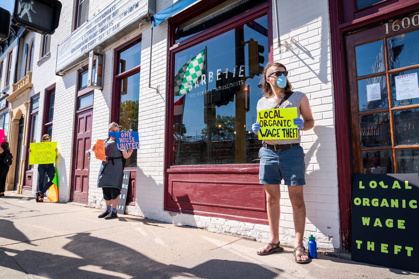 Nick Nootenboom, from right, who worked as a bartender at Tiny Diner, and Ace Fox, who worked as a cook at Gigi's Cafe, protested with six feet of social distancing between them outside of Barbette. ] LEILA NAVIDI • leila.navidi@startribune.com