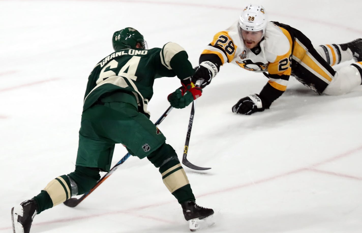 Michael Granlund(64) of the Wild slaps a goal in past Ian Cole(28).