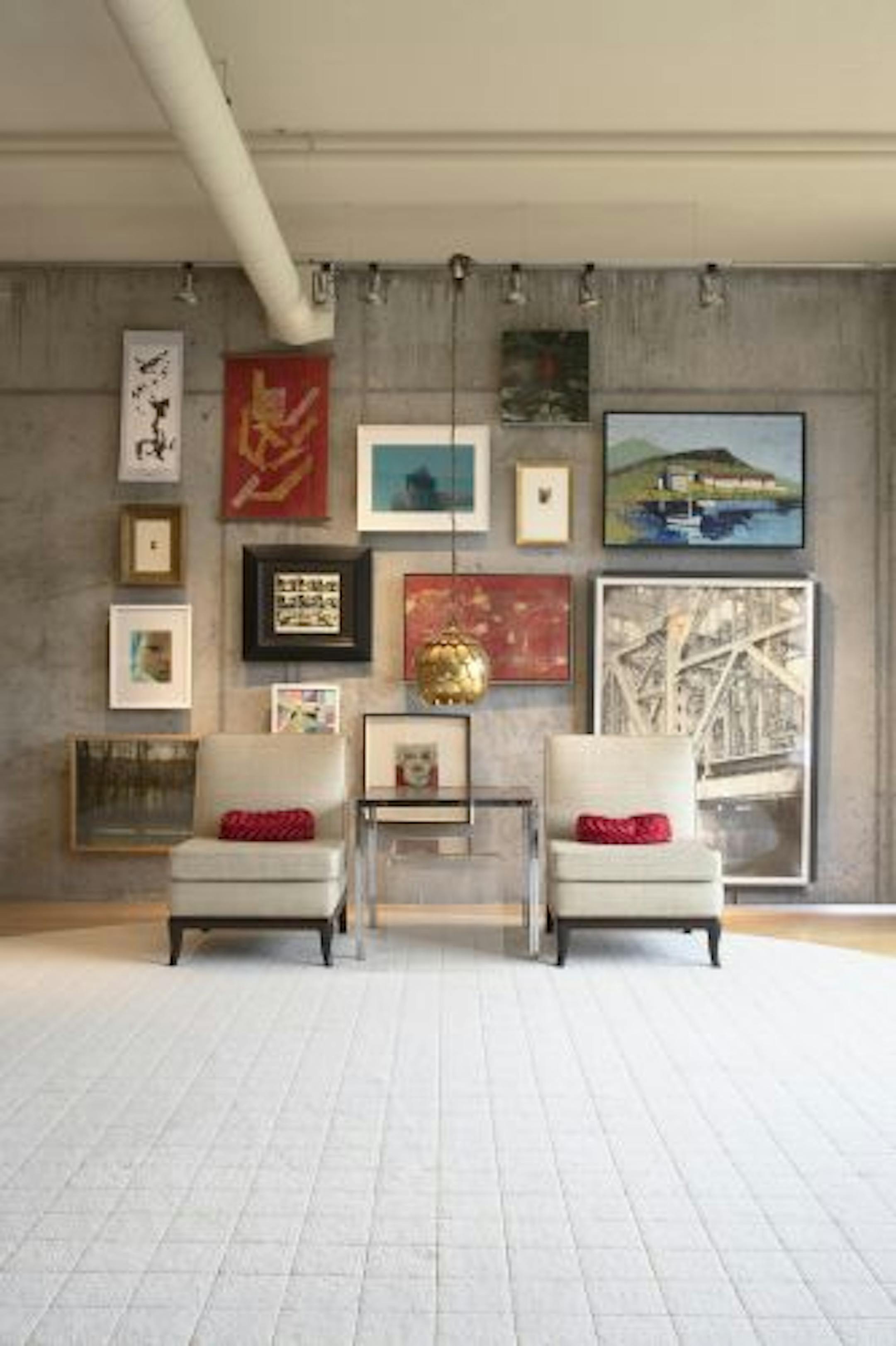 After: Designer/owner Michael Rabatin used a system of aluminum rail tracks, grippers with hooks and tension cables to hang an assortment of art.