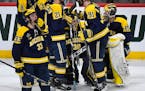 Teammates consoled Michigan Wolverines goaltender Hayden Lavigne (30) after he allowed the game winning goal by Notre Dame Fighting Irish forward Jake