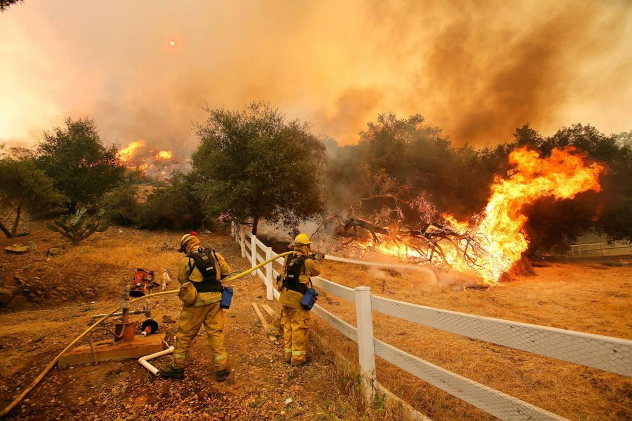 Ffirefighters from Stockton, Calif., put out flames off of Hidden Valley Rd. while fighting a wildfire, Friday, May 3, 2013 in Hidden Valley, Calif. A huge Southern California wildfire burned through coastal wilderness to the beach on Friday then stormed back through canyons toward inland neighborhoods when winds reversed direction. (AP Photo/Los Angeles Times, Mel Melcon) NO FORNS; NO SALES; MAGS OUT; ORANGE COUNTY REGISTER OUT; LOS ANGELES DAILY NEWS OUT; VENTURA COUNTY STAR OUT; INLAND VALLEY